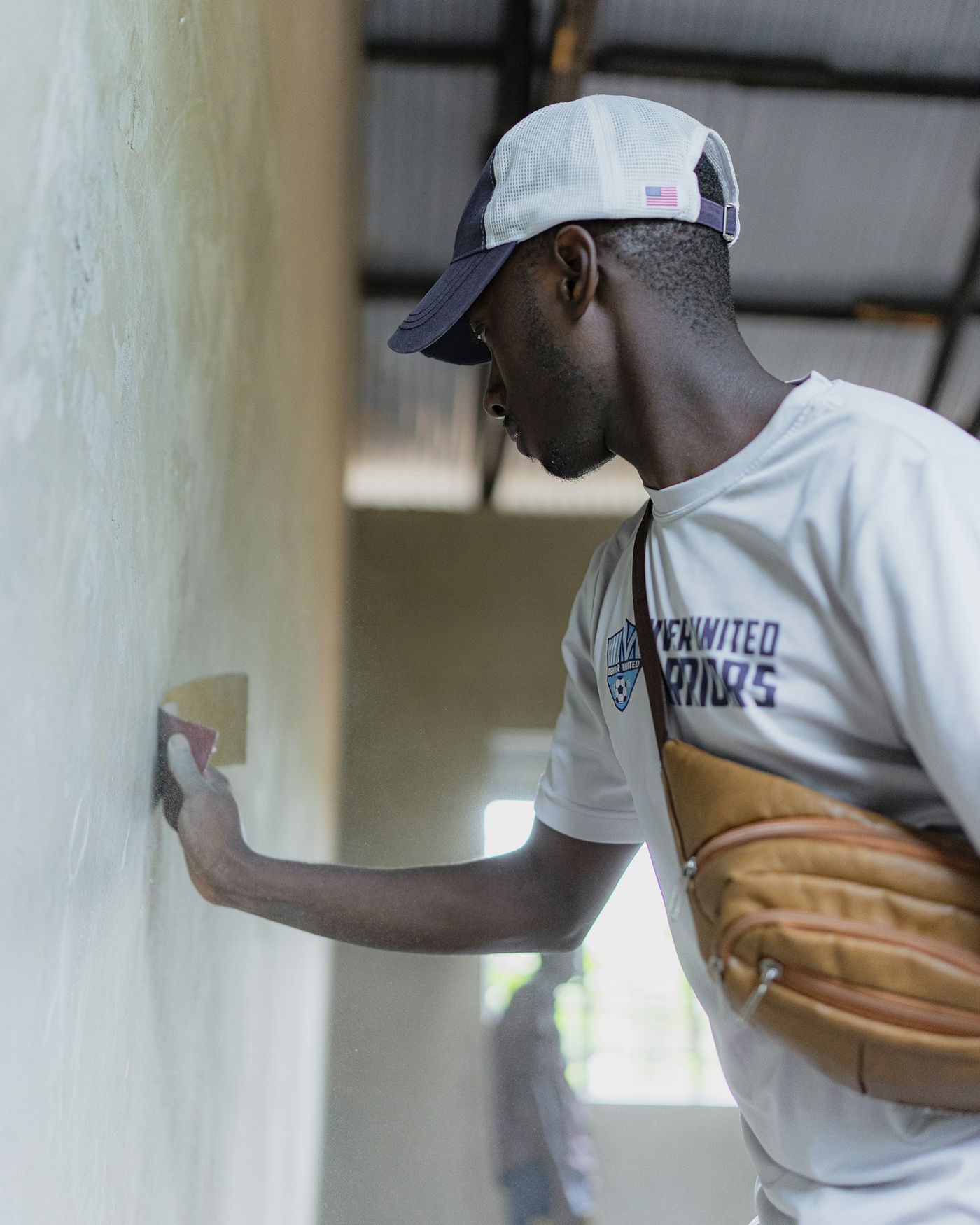 Craftsman applying smooth plaster finish to an interior wall with a trowel