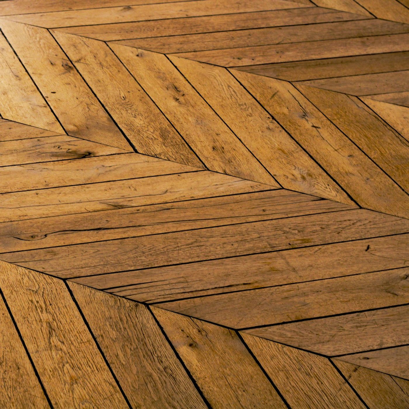 Close-up of a herringbone hardwood floor installation showcasing precise craftsmanship